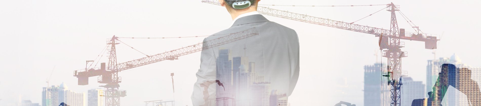 Focused builder with hard hat and tool belt at construction site