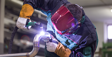 Skilled welder crafting precise welds with protective gear